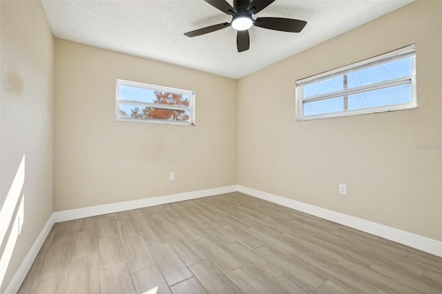 unfurnished room with a textured ceiling, light wood-type flooring, and ceiling fan