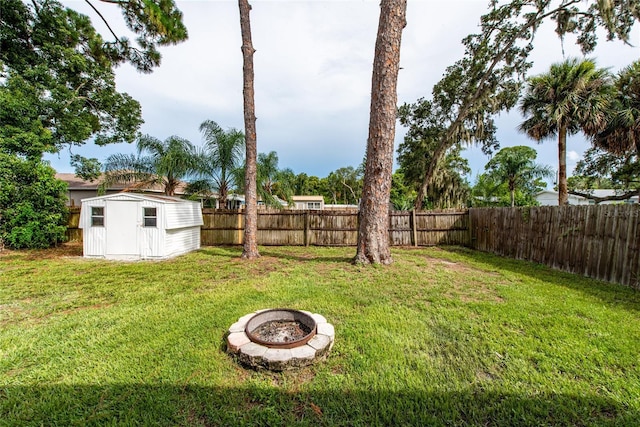 view of yard with a shed and an outdoor fire pit