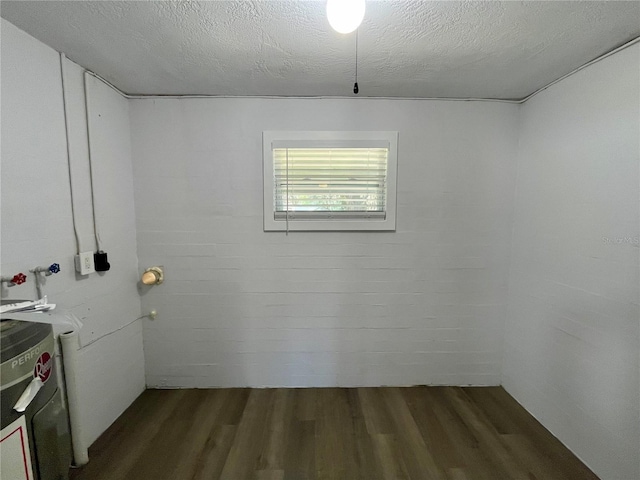 laundry area featuring washer / dryer, a textured ceiling, and dark wood-type flooring