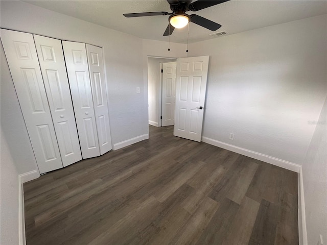 unfurnished bedroom featuring a closet, ceiling fan, and dark wood-type flooring