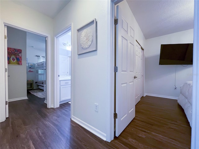 hall featuring a textured ceiling, dark hardwood / wood-style flooring, and lofted ceiling