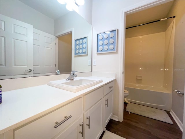 full bathroom featuring hardwood / wood-style floors, vanity, toilet, and bathtub / shower combination