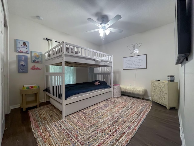 bedroom with ceiling fan and dark wood-type flooring