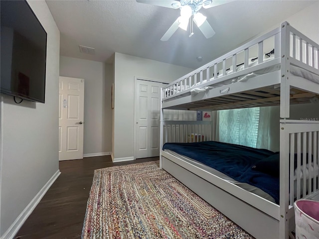 bedroom with ceiling fan, dark hardwood / wood-style flooring, and a closet