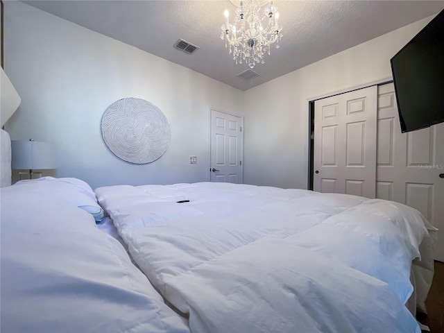 bedroom featuring a textured ceiling and a notable chandelier