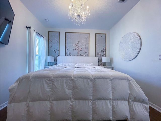 unfurnished bedroom with wood-type flooring, a textured ceiling, and an inviting chandelier