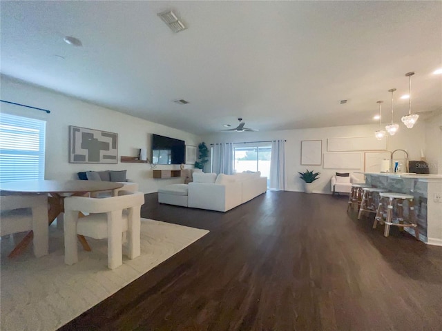 living room with ceiling fan and dark wood-type flooring