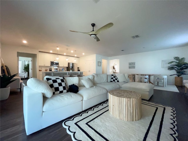 living room featuring dark hardwood / wood-style flooring and ceiling fan