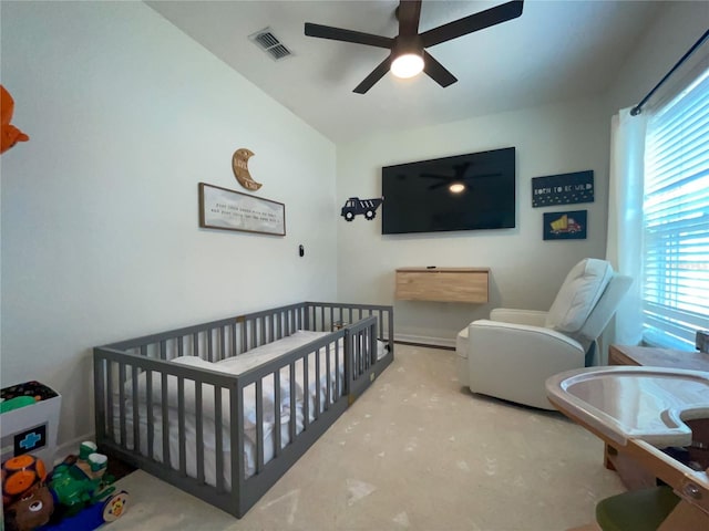 bedroom with a crib, ceiling fan, and lofted ceiling