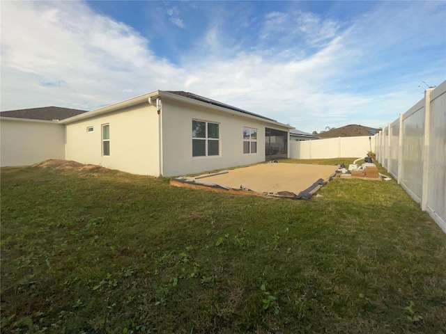 rear view of property featuring a lawn and a patio