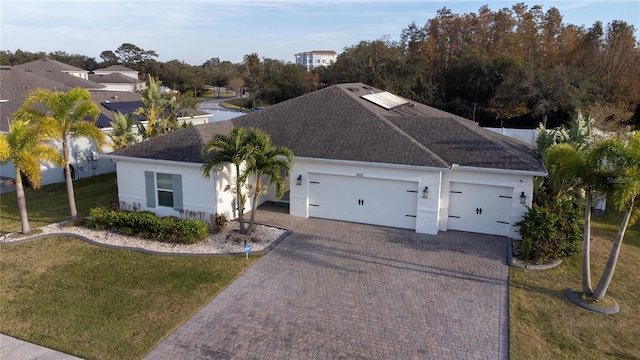 view of front of home with a garage and a front lawn