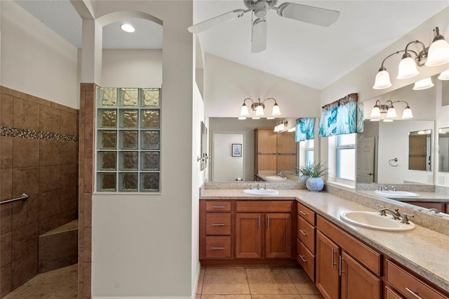 bathroom with ceiling fan, vanity, a shower, vaulted ceiling, and tile patterned floors