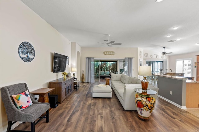 living room featuring ceiling fan, dark hardwood / wood-style floors, and a textured ceiling