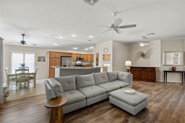 living room with dark hardwood / wood-style floors, washer / clothes dryer, and a textured ceiling