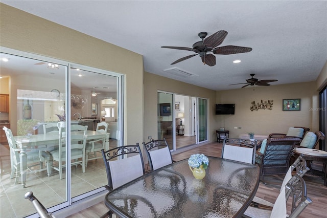 dining space featuring light wood-type flooring and a textured ceiling