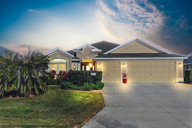 view of front of property featuring a garage and a lawn