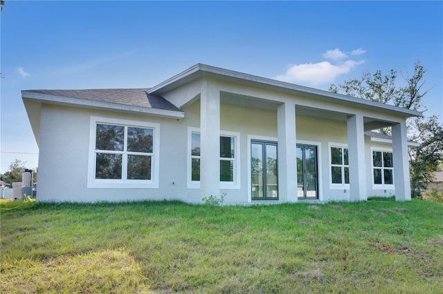 rear view of property featuring a yard