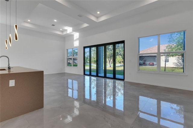 interior space with a towering ceiling, a tray ceiling, and sink