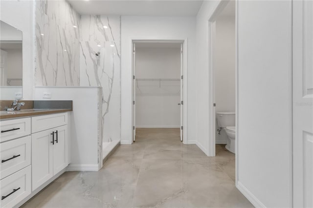 bathroom featuring a shower, vanity, and toilet