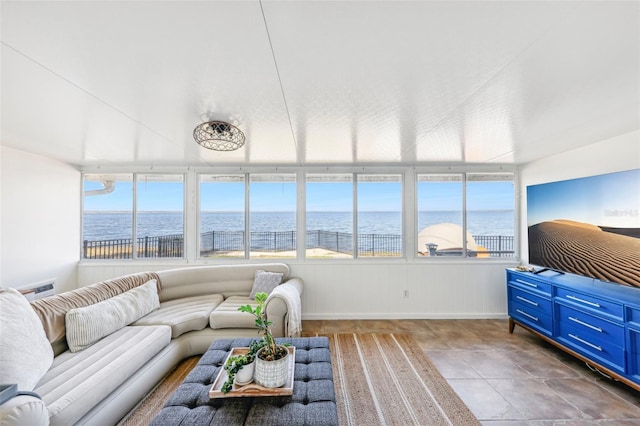 sunroom featuring a water view