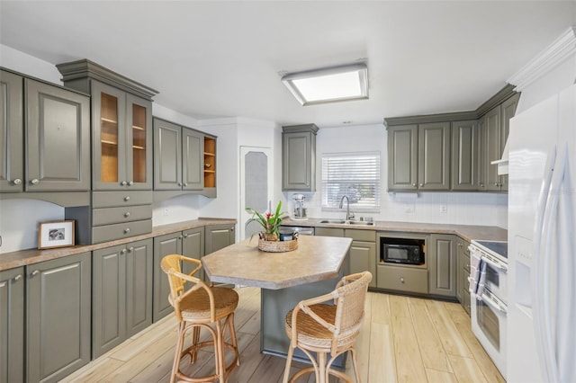 kitchen featuring white appliances, light hardwood / wood-style floors, gray cabinetry, and sink