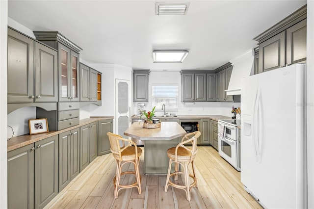 kitchen featuring light hardwood / wood-style floors, white appliances, a kitchen bar, a kitchen island, and custom exhaust hood