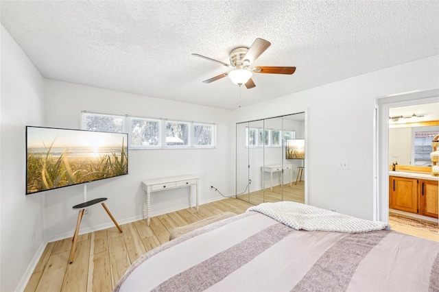 bedroom with ceiling fan, a closet, a textured ceiling, and light wood-type flooring