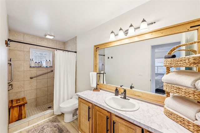 bathroom with tile patterned floors, vanity, toilet, and curtained shower