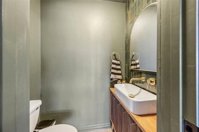 bathroom with backsplash, vanity, and toilet