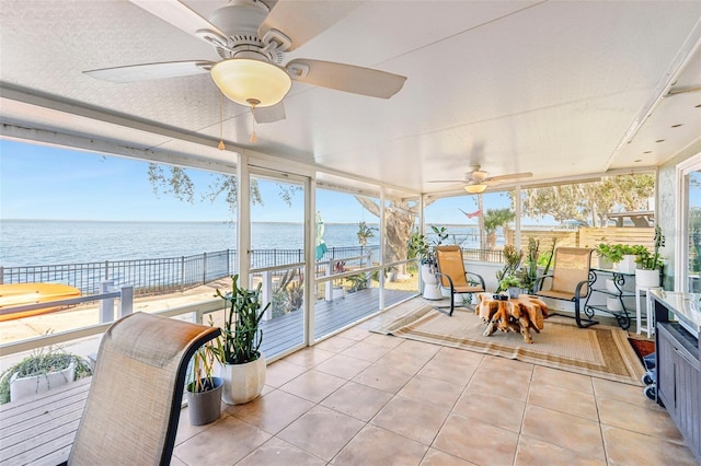 sunroom / solarium with a wealth of natural light, a water view, and ceiling fan