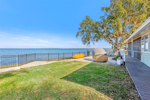 view of yard featuring a sunroom and a water view