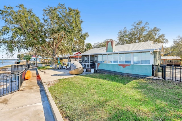 exterior space featuring a sunroom and a water view