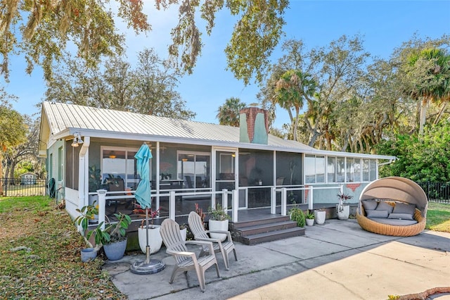 rear view of property featuring a patio area and a sunroom