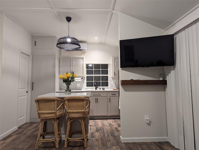 kitchen featuring pendant lighting, a breakfast bar, backsplash, sink, and dark hardwood / wood-style flooring