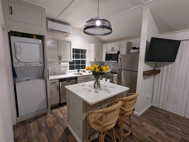 kitchen featuring decorative backsplash, appliances with stainless steel finishes, stacked washing maching and dryer, and dark hardwood / wood-style floors