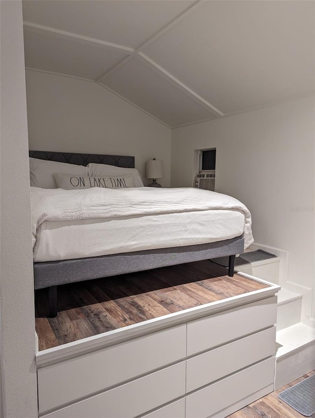 unfurnished bedroom with hardwood / wood-style flooring and lofted ceiling