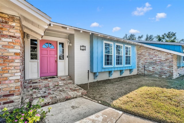 property entrance with a lawn