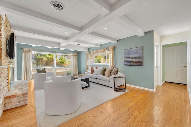 living room with beam ceiling, a brick fireplace, coffered ceiling, and light wood-type flooring