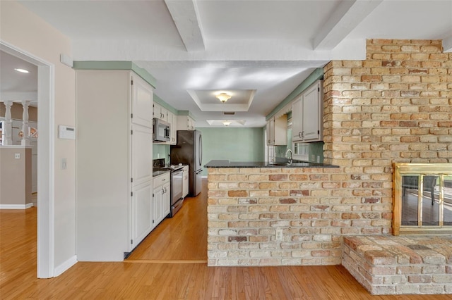 kitchen featuring kitchen peninsula, light hardwood / wood-style flooring, white cabinets, and appliances with stainless steel finishes