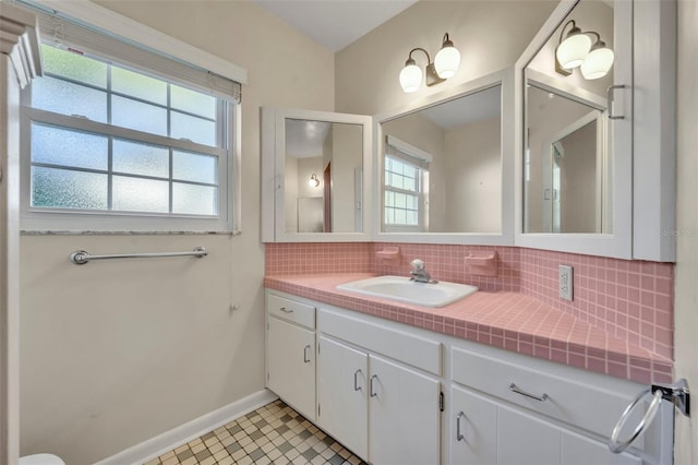 bathroom featuring decorative backsplash, vanity, a wealth of natural light, and tile patterned flooring