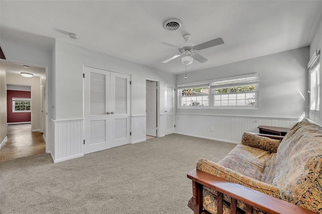 living area with light colored carpet and ceiling fan