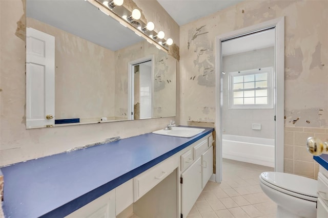 bathroom with tile patterned floors, a tub to relax in, vanity, and toilet