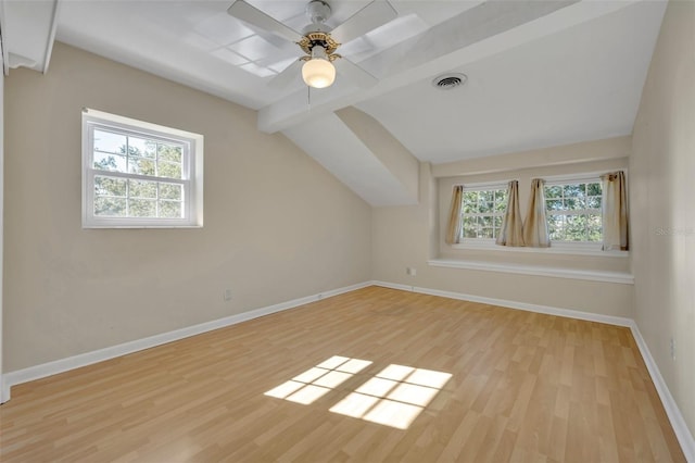 additional living space featuring vaulted ceiling with beams, a healthy amount of sunlight, ceiling fan, and light hardwood / wood-style flooring