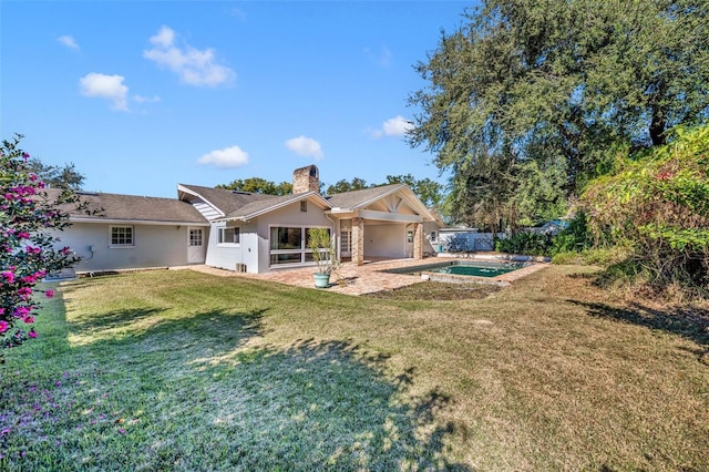 rear view of house with a yard and a patio area