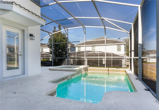 view of pool featuring an in ground hot tub, a patio, and glass enclosure