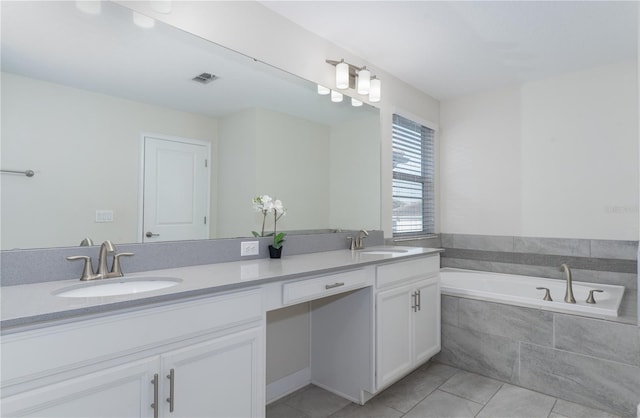 bathroom with tiled bath, tile patterned flooring, and vanity