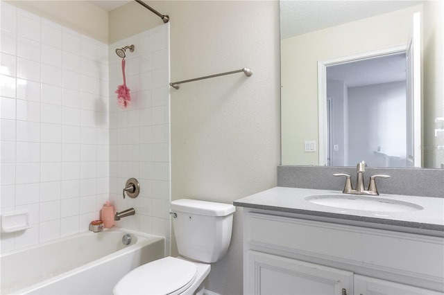 full bathroom featuring vanity, tiled shower / bath combo, and toilet