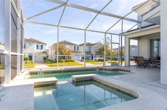 view of swimming pool with an in ground hot tub, glass enclosure, and a patio area