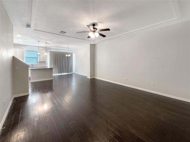 unfurnished living room with dark hardwood / wood-style flooring and ceiling fan