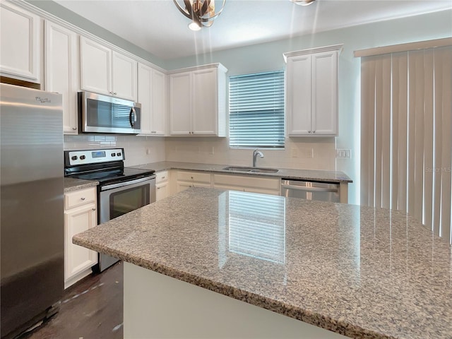 kitchen with light stone countertops, sink, stainless steel appliances, backsplash, and white cabinets